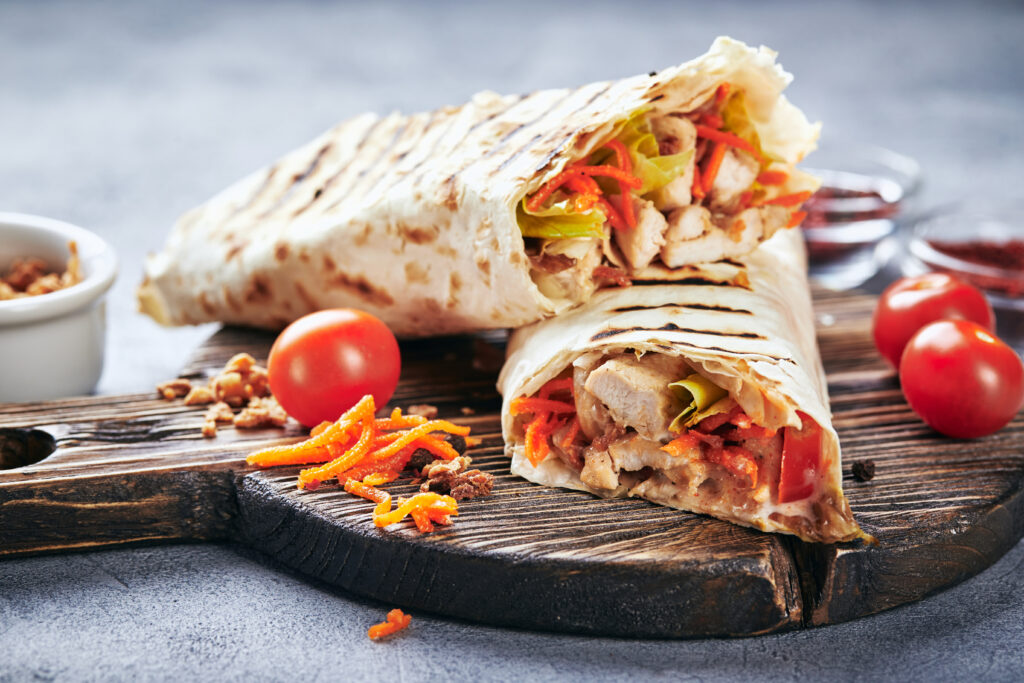 Eastern traditional shawarma with chicken and vegetables, Doner Kebab with sauces on slate. Fast food. Eastern food.