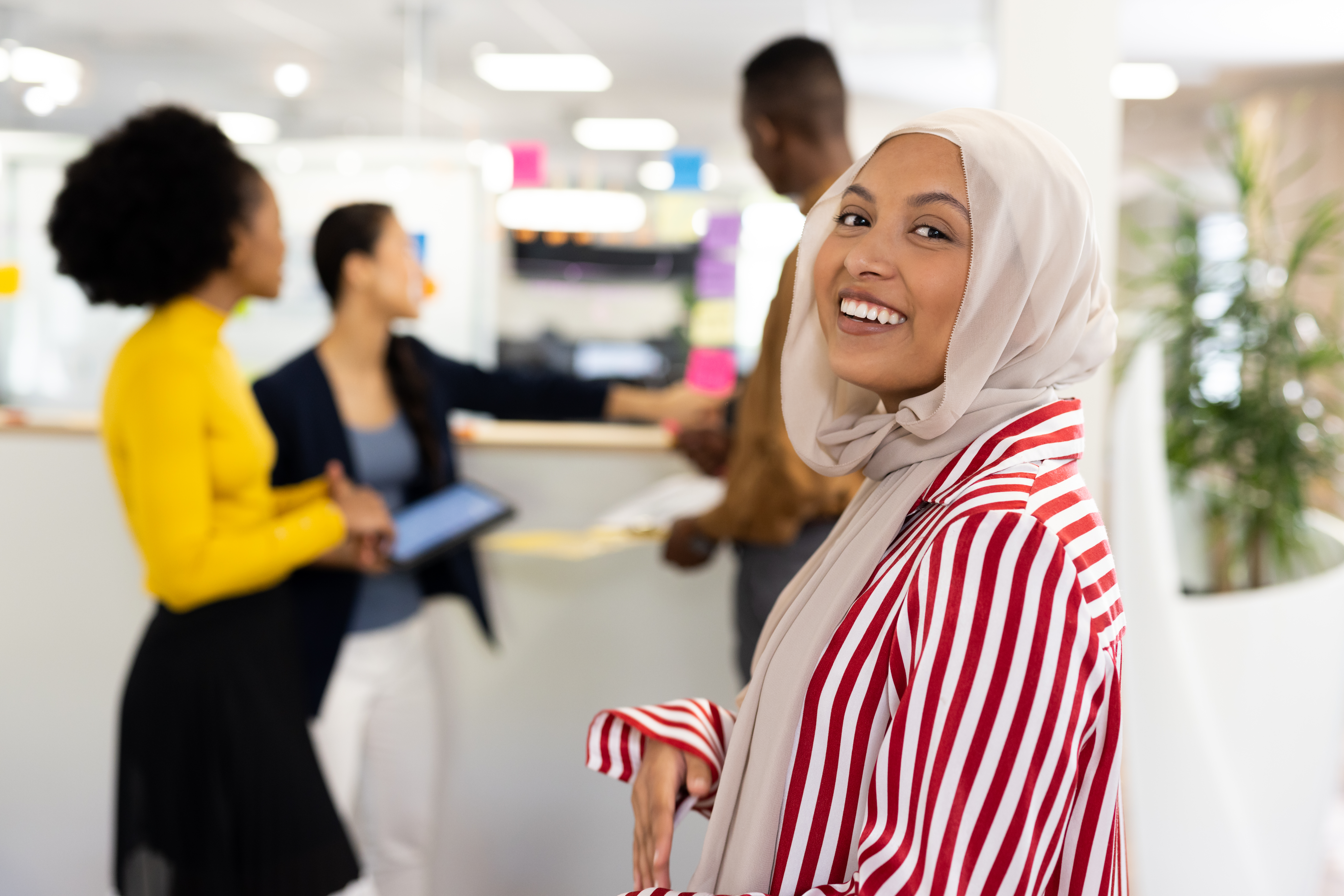 Happy middle-east woman in hijab smiling at camera in office. Business, corporation, working in office and cooperation concept.